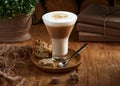 Cafe latte macchiato layered coffee in a glass cup.The cup is on a rustic Wooden Table Royalty Free Stock Photo