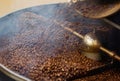 Cafe, mix and coffee beans in a machine for a raw blend, textures and steam in a pot. Food, industry and espresso and