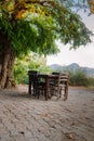 Cafe in Nature, Wooden Chairs and table under old tree Royalty Free Stock Photo