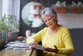 Cafe, newspaper and senior woman reading daily news, article story or morning paper in store. Coffee shop customer Royalty Free Stock Photo