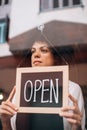 Cafe owner putting an open sign on the glass door Royalty Free Stock Photo