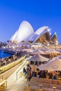 Cafe with people and the Sydney Opera House at twilight