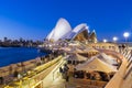 Cafe with people and the Sydney Opera House at twilight