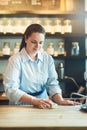 The cafe remains spotless under her management. a young woman cleaning a countertop in her cafe. Royalty Free Stock Photo