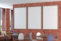 Cafe or restaurant intrerior with blank three vertical posters on the red brick wall. Royalty Free Stock Photo