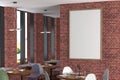 Cafe or restaurant intrerior with blank vertical poster on the red brick wall. Royalty Free Stock Photo