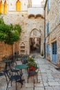 Cafe tables and chairs outside in old cozy street in the in old medieval town Hvar in outdoor restaurant with nobody Royalty Free Stock Photo