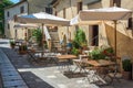 Cafe tables and chairs in a street in the village of Bagno Vignoni, Tuscany Italy Royalty Free Stock Photo