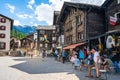 Cafe terrace with tourists and old houses during summer in Zermatt Switzerland