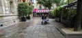Cafe waiter takes a break on Paris plaza, checks cell phone