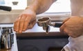 A cafe worker brings freshly ground coffee to a coffee machine Royalty Free Stock Photo