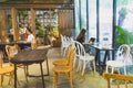 Cafeteria Interior with modern design and furniture decorated with plenty of green plants and wood materials in Vietnam