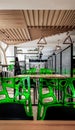 Cafeteria, no people dining room with wooden tables and green chairs. Interior with wood and metal elements. Modern dining areas