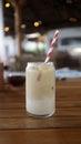Caffe latte with a colorful straw in a medium glass in a table Royalty Free Stock Photo