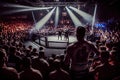 cage fight arena with packed crowd, cheering on their favorite fighter