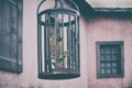 A cage with a scary skeleton hanged outdoors. Window old house and cage with bones dead man Royalty Free Stock Photo