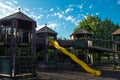 Beautiful wooden children`s playground with yellow slide at the park in italy Ex - Vetreria. Blue sky with some clouds in backg