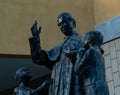 Bronze statue of Don Bosco with two children Royalty Free Stock Photo