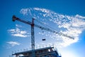 A tower crane with hoists builds a future modern condominium building, background Royalty Free Stock Photo