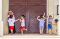 Children playing and romping around at the entrance of a cathedral in Cai Be, Vietnam