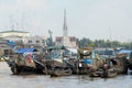 View to the boats floating on water with the church at the background in Cai Be, Vietnam.