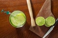 Caipirinha. A brazilian drink made with lime, cachaÃÂ§a, sugar and ice. wood background. slices of lemon, and a knife.