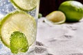 Caipirinha, Mojito cocktail, vodka or soda drink with lime, mint and straw on sand background. Close-up Royalty Free Stock Photo