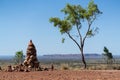 Cairn and gum tree with outback landscape in background in NT Australia Royalty Free Stock Photo