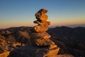 Cairn with mountains in the background at sunset