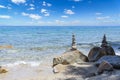 Cairn of pebbles, Zen stack of stones on the sea stone beach under blue sky with clouds during sunny day in Greece Royalty Free Stock Photo