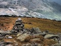 Cairn (pile of rocks) on White Mountains, New Hampshire, with hut in the distance