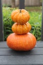 A cairn of three small pumpkins stacked one upon the other