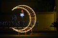 Cairo, Egypt, April 17 2023: A crescent made with led lights with Ramadan Fanous lamp lantern in the street as a festive sign