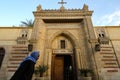 An Old Egyptian Copt walking past the entrance to the Hanging Church of Coptic Cairo, Egypt. Royalty Free Stock Photo