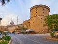 CAIRO, EGYPT - DECEMBER 21, 2017: The tall stone wall of Saladin Citadel with old watchtowers and rising minarets of Alabaster Royalty Free Stock Photo