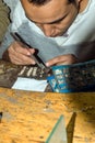 Cairo, Egypt February 20, 2017: Egyptian artisan making silver and jet pendants called cartridges