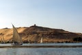 Cairo, Egypt February 17, 2017: Turku Nile River boats called felucca loaded with tourists passing under a huge desert dune with t Royalty Free Stock Photo