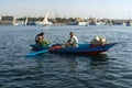 Two Arab fishermen in a small boat typical of the Nile River, one paddling and the other crouching