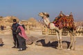 CAIRO, EGYPT - JANUARY 28, 2019: Camel handler with a tourist in front of the Pyramid of Khafre in Giza, Egy Royalty Free Stock Photo