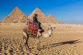 CAIRO, EGYPT - JANUARY 28, 2019: Camel rider in front of the Great pyramids of Giza, Egy Royalty Free Stock Photo