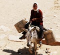 Cairo / Egypt - May 7, 2008: Woman on a donkey carries water cans in Cairo.