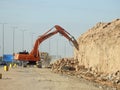 demolition hydraulic crawler excavator removing prats from a hill or a mountain on the roadside to develop and widen the highway