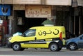 Cairo, Egypt, November 25 2022: Noon online shopping delivery yellow van to deliver a package, Arabic Translation (Noon.com