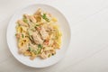 Cajun chicken Fettuccine pasta in a creamy sauce on white plate. Top view