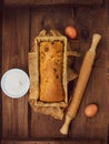 Cake in baking mold with rolling pin rural rustic wooden background flat lay. Pastry dough recipe ingredients with eggs Royalty Free Stock Photo