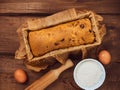 Cake in baking mold with rolling pin rural rustic wooden background flat lay. Pastry dough recipe ingredients with eggs Royalty Free Stock Photo