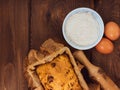 Cake in baking mold with rolling pin rural rustic wooden background flat lay. Pastry dough recipe ingredients with eggs Royalty Free Stock Photo