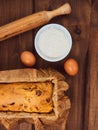 Cake in baking mold with rolling pin rural rustic wooden background flat lay. Pastry dough recipe ingredients with eggs Royalty Free Stock Photo