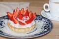 Cake basket with buttercream and fresh strawberries on top. Cupcake dessert and coffee in a cafe Royalty Free Stock Photo