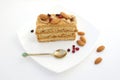 Cake with berries and almonds on a white plate with a Golden spoon. A tasty treat for tea.
